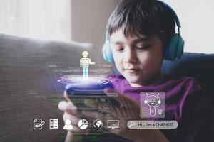 educación tecnológica, niño de la escuela que sostiene un teléfono móvil y usa auriculares que tocan o escuchan un chatbot para la tarea, niño que usa el sistema ai chatbot en una aplicación móvil para investigar en Internet foto