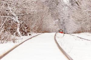 un viejo tranvía moviéndose a través de un bosque de invierno foto