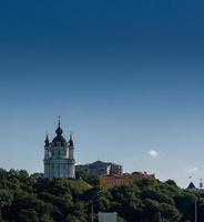 Beautiful church on a mountain with trees against a blue sky background photo