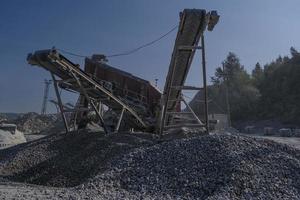 cinta transportadora en la cantera para la extracción y producción de piedra triturada en un día de verano foto