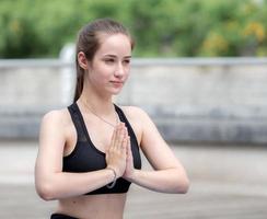 Woman practices yoga namaste position opening soul heart chakra at chest. Female serene people doing meditation in tranquil outdoor, concentrate on prayer pose. Mental wellbeing healthy lifestyle. photo