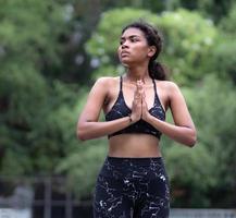 Woman practices yoga namaste position opening soul heart chakra at chest. Female serene people doing meditation in tranquil outdoor, concentrate on prayer pose. Mental wellbeing healthy lifestyle. photo