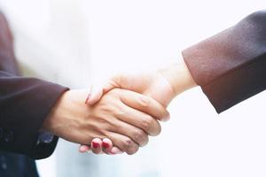 Closeup of a business man hand shake between two colleagues greet , Represents Friendship is good,success, congratulations. outdoor of building background. copy leave space for text. photo