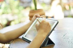 Female hand working looking at plan on computer in cafe photo