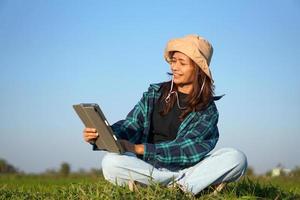 Asian female farmer delighted with rice growth target. Computer analysis photo