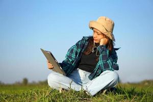 Asian female farmer uses computer to analyze rice growth. photo