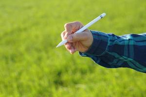 Asian female farmers use computers to analyze the growth of rice plants. photo