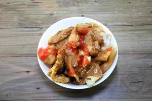 fried batagor on a white bowl. batagor is an Indonesian snack food, usually enjoyed with the addition of peanut sauce, soy sauce and chili sauce. photo