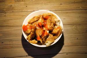 fried batagor on a white bowl. batagor is an Indonesian snack food, usually enjoyed with the addition of peanut sauce, soy sauce and chili sauce. photo