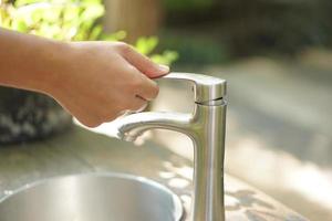 Female hands open water to wash hands photo