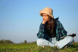 Asian female farmer is sad that the rice growth is not reaching the target. Use computer to analyze. photo