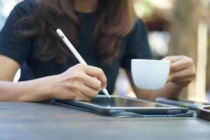 Female hand working looking at plan on computer in cafe photo