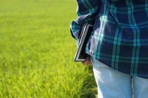 Asian female farmers use computers to analyze the growth of rice plants. photo