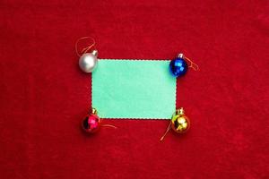 Christmas red background with white leaf and balls and branches of Christmas tree. photo