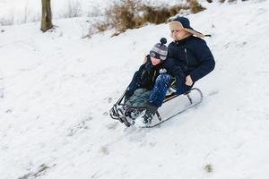 Dad and son ride in sledding, baby is fun photo