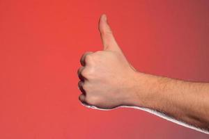 Close-up of a hand with a fingernail up of an isolated on a red background photo