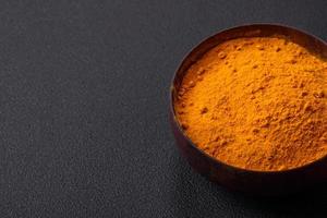 Bright yellow turmeric or curry spice for Asian food preparation photo