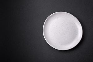 Empty ceramic round plate on dark textured concrete background photo