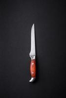 Metal kitchen knife on a dark textured concrete background photo