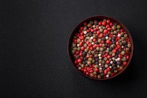 Spice allspice of different colors pink, white, green not ground in a wooden saucer photo