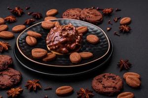 Delicious chocolate tart with nuts on a black ceramic plate photo