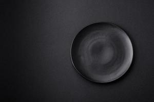 Empty ceramic round plate on dark textured concrete background photo