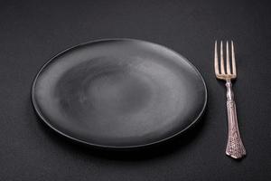 Empty ceramic round plate on dark textured concrete background photo