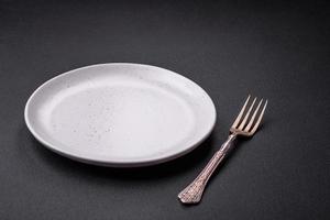 Empty ceramic round plate on dark textured concrete background photo