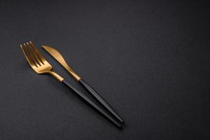 cuchillo y tenedor de cocina de metal sobre un fondo de hormigón texturado oscuro foto