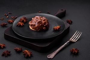 deliciosa tarta de chocolate con nueces en un plato de cerámica negra foto