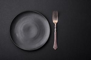 Empty ceramic round plate on dark textured concrete background photo