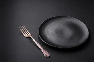 Empty ceramic round plate on dark textured concrete background photo