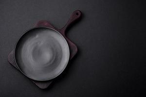 Empty ceramic round plate on dark textured concrete background photo