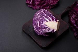 Fresh beautiful red cabbage with textured leaves on a dark concrete background photo
