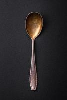 Empty metal spoon on dark textured concrete background photo