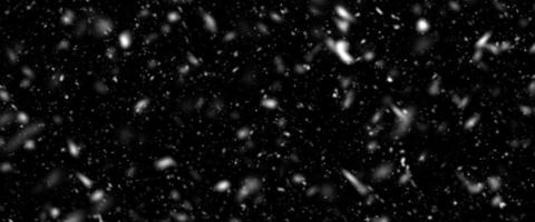 Bokeh de nevadas sobre base oscura. numerosos copos de nieve volando en el aire. nevadas nocturnas de invierno y tormenta de nieve en. base innovadora de impacto de luz de bokeh oscura. foto