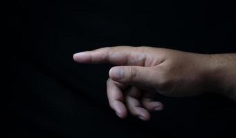 hand pointing forward isolated on black photo