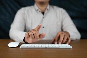 man facing the touchscreen computer with cursor and keyboard in front of him photo