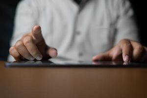 Man holding tablet while pointing to the front. Background of business concepts with digital technology photo