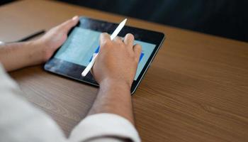 Hands holding pens and tablets for writing business plans photo