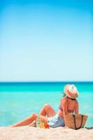 Young woman in hat sunbathing on the beach photo