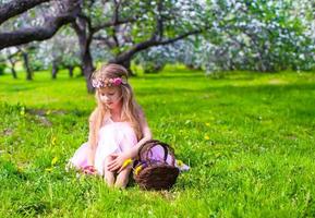 Happy little adorable girl in blossoming apple tree garden photo