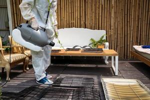 Professional technical man in prevention suit with his sterilizing machine and disinfecting water sprays the air conditioner filter for purifying coronavirus photo