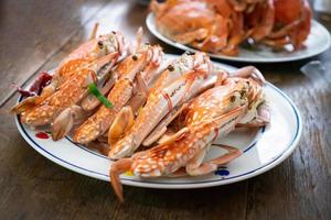 steamed crab in the dish on the old wood table. photo