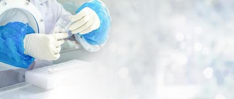 Close up to the rubber gloves on the asian medical staff is processing coronavirus or covid-19 test in the negative room pressure. photo