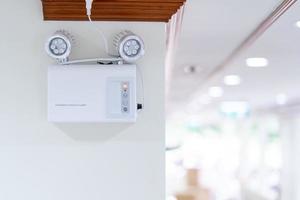 Automatic EMERGENCY LIGHT in hospital is charging and power pluging on the wall that ready to use when the power went out. photo