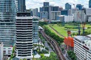 horizonte aéreo de bangkok y vista de skytrain de tailandia. centros de áreas de edificios comerciales y financieros con un parque verde inteligente entre la ciudad urbana al mediodía. foto
