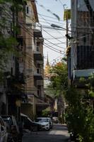 concéntrese en la montaña dorada, el templo antiguo de tailandia y el punto de referencia detrás de la construcción de viviendas local con un cable descuidado por todas partes. foto