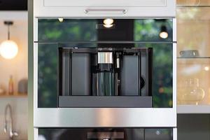 Contemporary and modern Coffee machine building furniture in the kitchen. photo