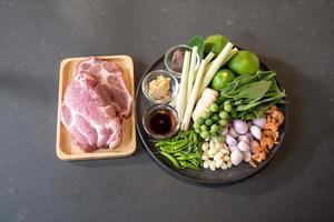 topview flatlay de cerdo crudo e ingredientes de hierbas, preparación para cocinar en el menú de comida tailandesa. trazados de recorte. foto